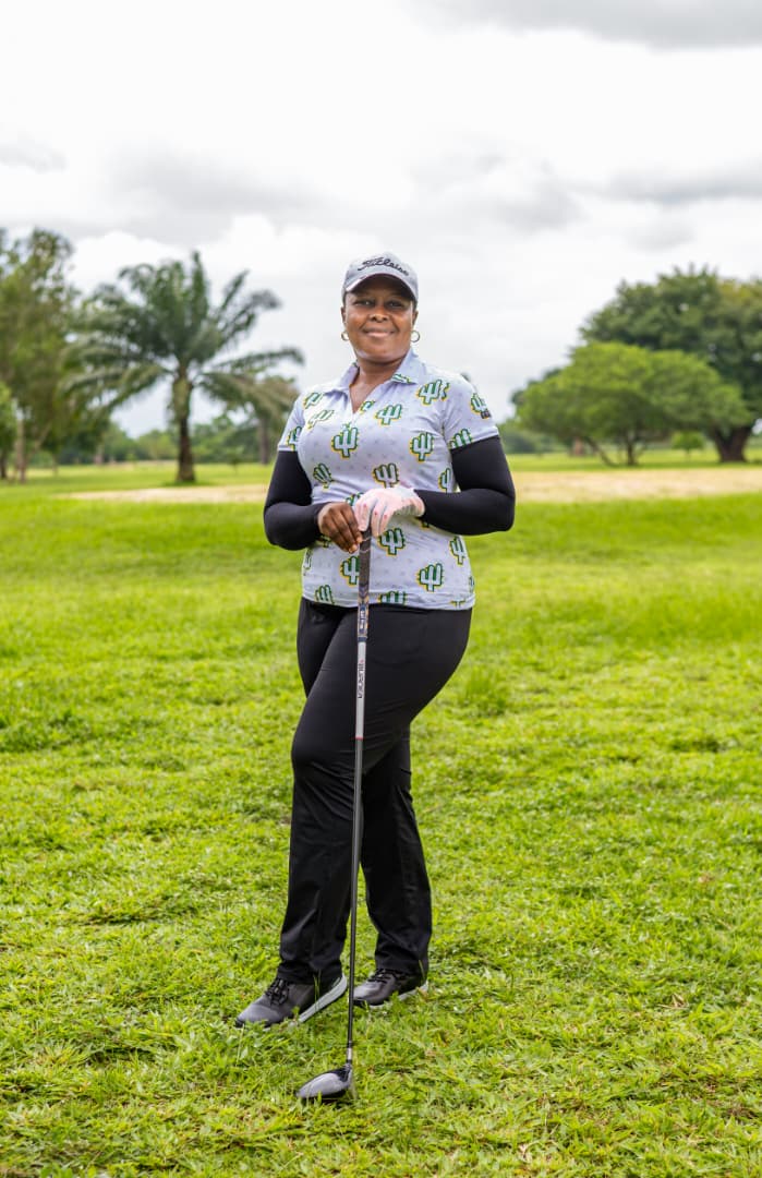 Lady member smiling, leaning on her driver on the fairway