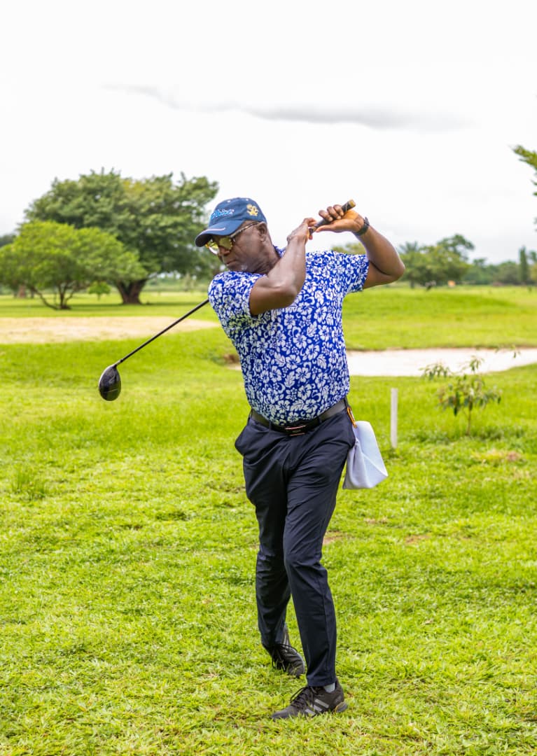 Golfer completing a powerful drive with the bunker behind