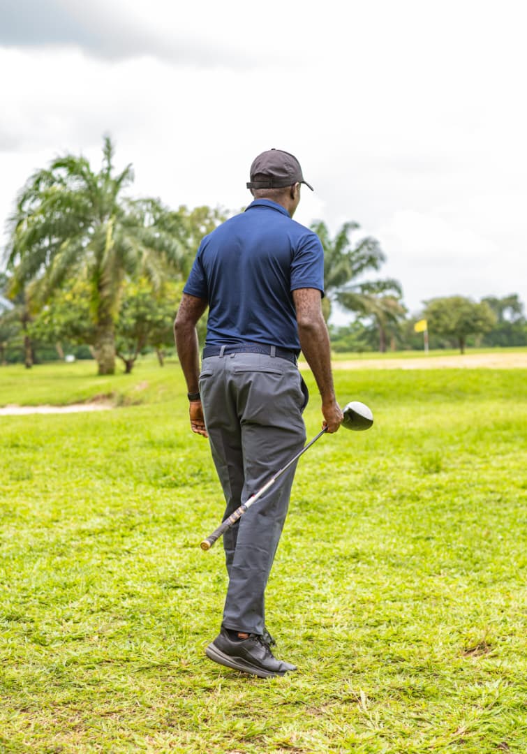 Golfer walking away down the fairway, driver in hand