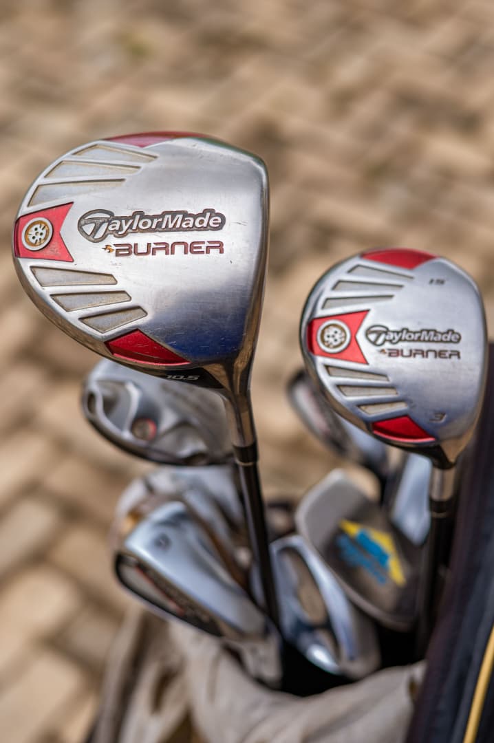 Close-up of drivers and irons in a golf bag by the clubhouse